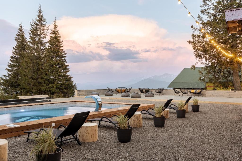 a resort pool with chairs and a view of the mountains at Gremi Hotel in Dragobrat