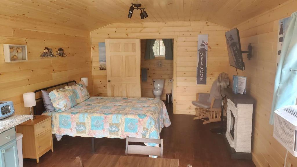 a bedroom with a bed in a log cabin at Lighthouse Cabins Maine in Bass Harbor