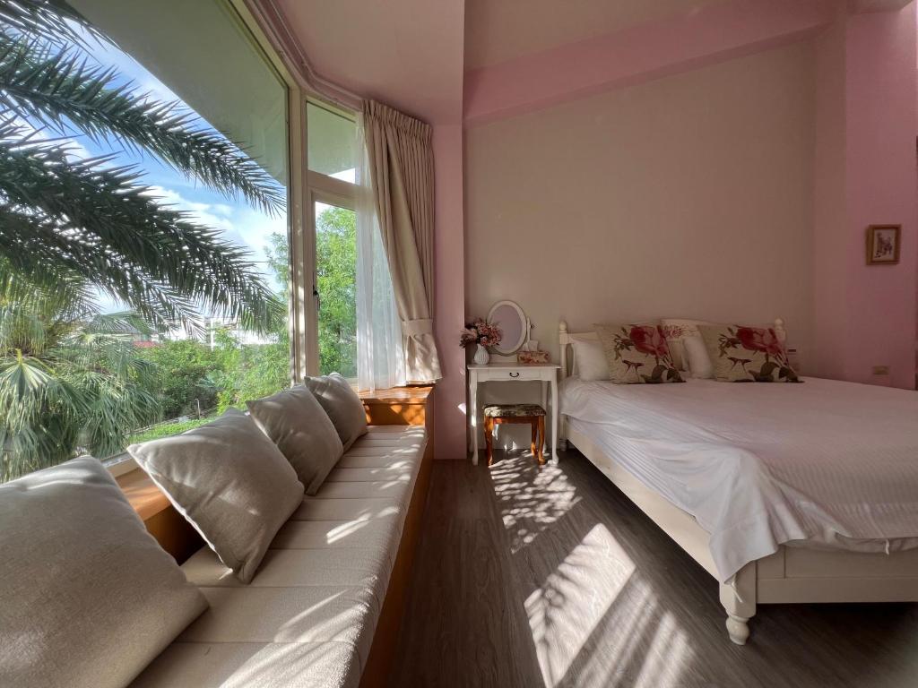 a bedroom with a bed and a large window at Annongriver B&B in Sanxing