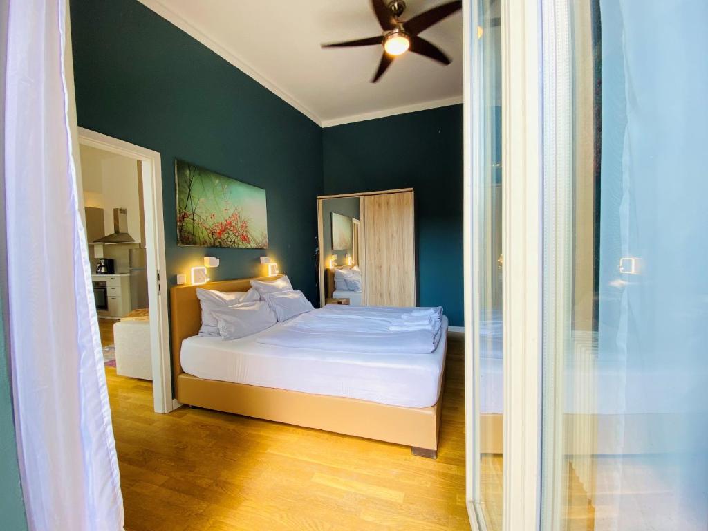 Schlafzimmer mit einem Bett und einem Deckenventilator in der Unterkunft Amaroo - Apartments Potsdam “Brandenburger Tor” in Potsdam
