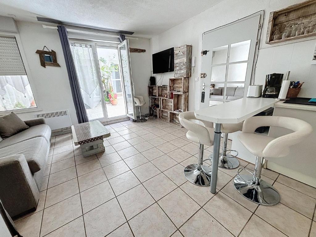 une cuisine et un salon avec une table et des chaises dans l'établissement Jaurès cœur de ville, à Sète