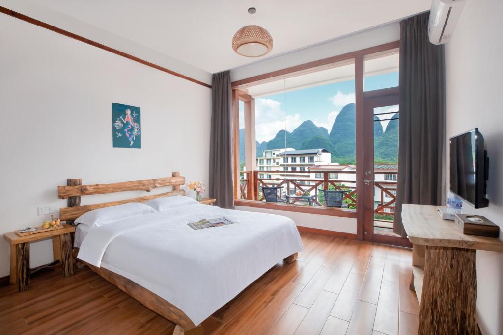 una camera con un letto e una grande finestra di Yangshuo Xiao Long River Hotel a Yangshuo