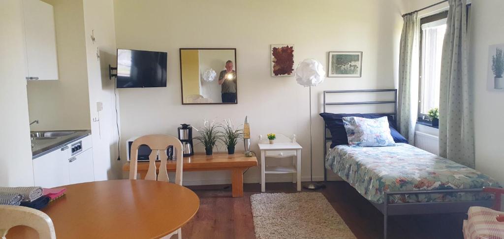 a small room with a table and a bed and a table and chair at Ekhult Apartments - Ground Floor - Garden and Lake View in Ulricehamn