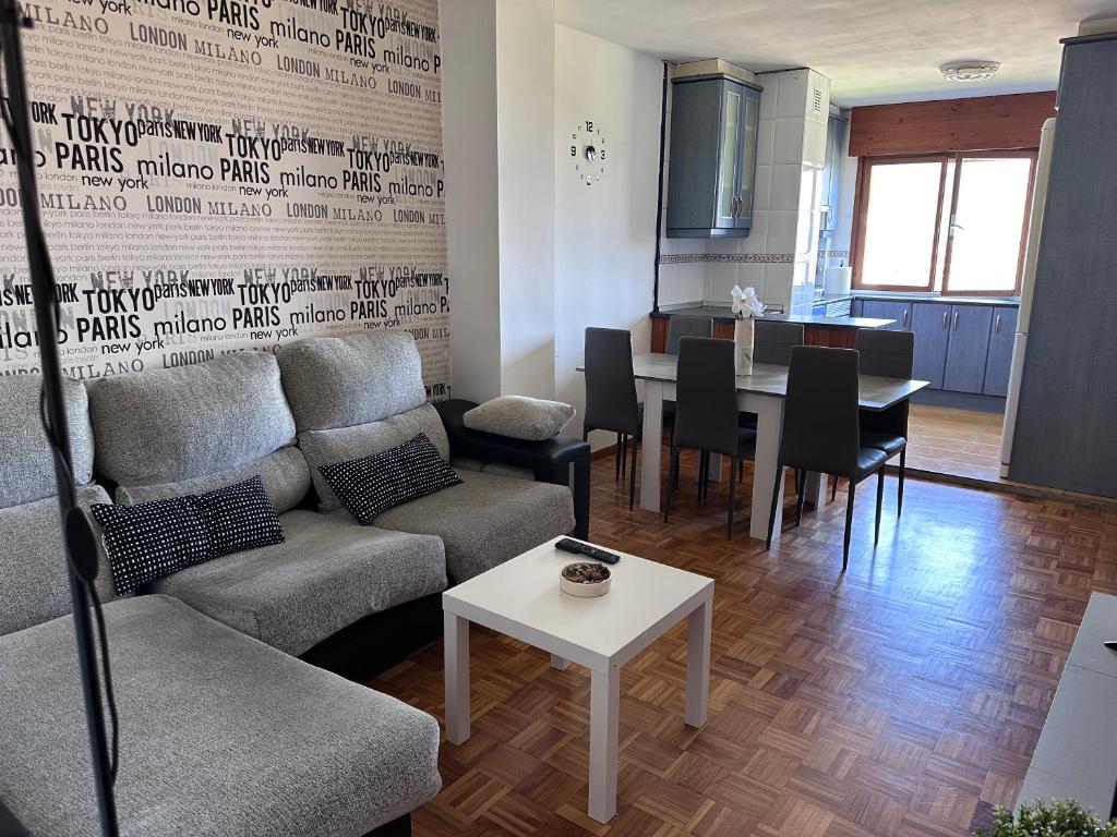 un soggiorno con un divano e un tavolo di Acogedor Apartamento con vistas a la Catedral y parking a Oviedo