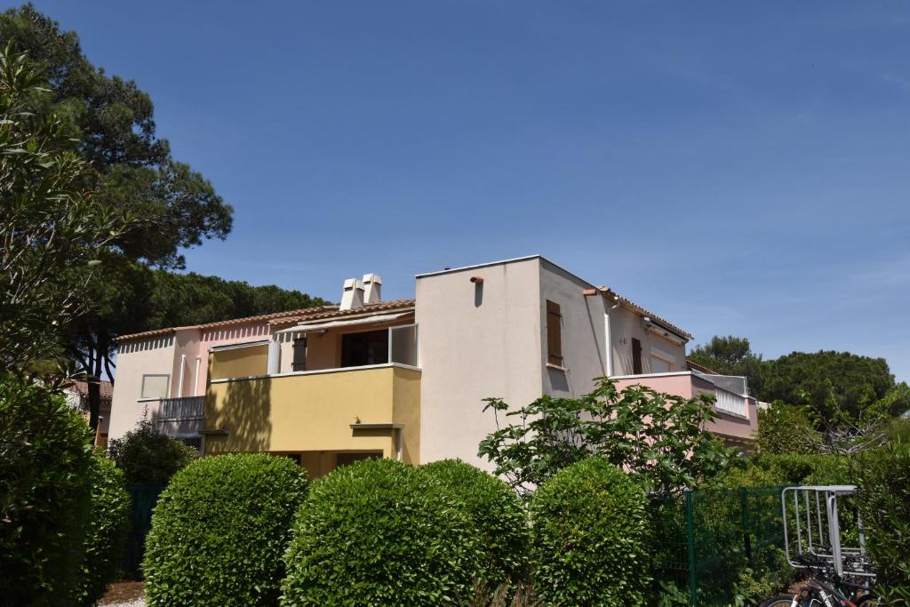 un bâtiment avec des buissons devant lui dans l'établissement Appartement résidence EUREKA T2-piscine-parking, au Cap d'Agde
