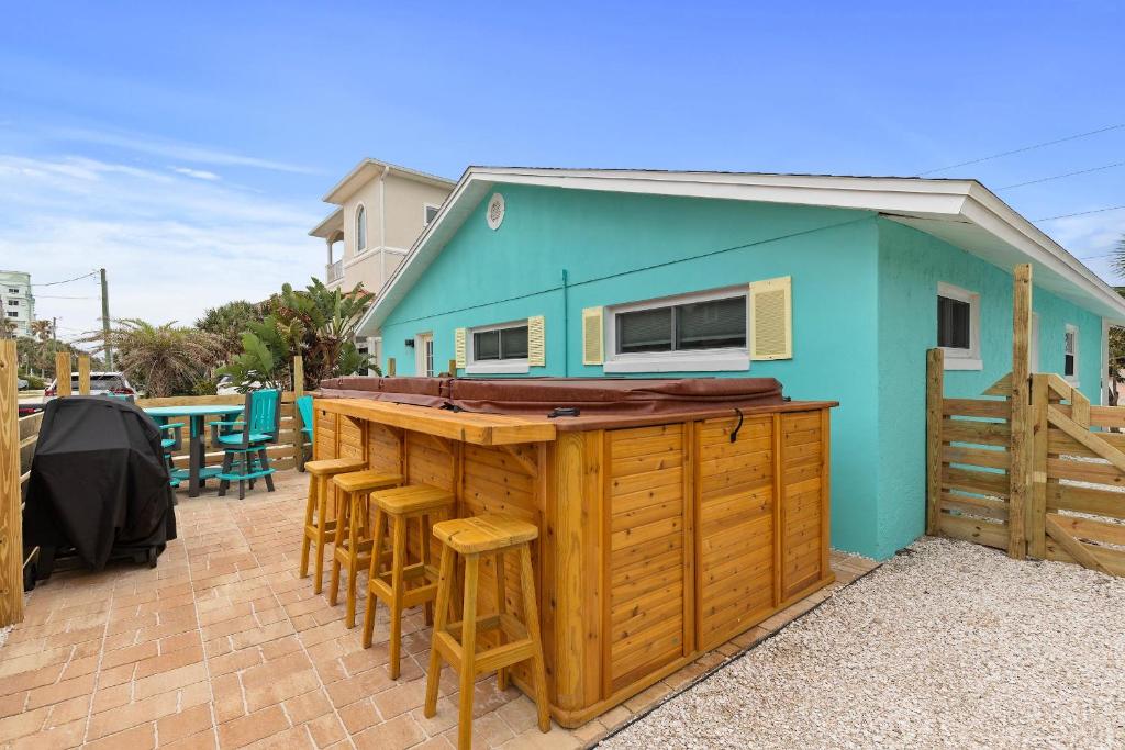 Una casa azul con una barra con taburetes alrededor. en Aqua Beach Bungalow, en New Smyrna Beach