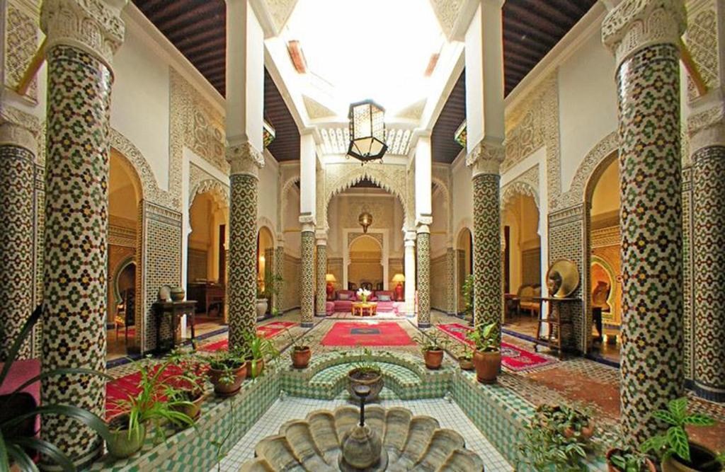a lobby with a pool in the middle of a building at Dar El Mouhit in Salé