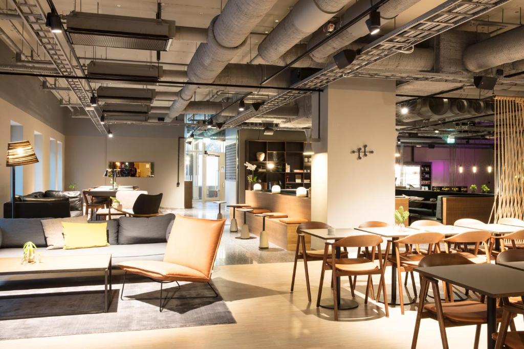 - un hall avec un canapé, des tables et des chaises dans l'établissement Comfort Hotel Kista, à Stockholm