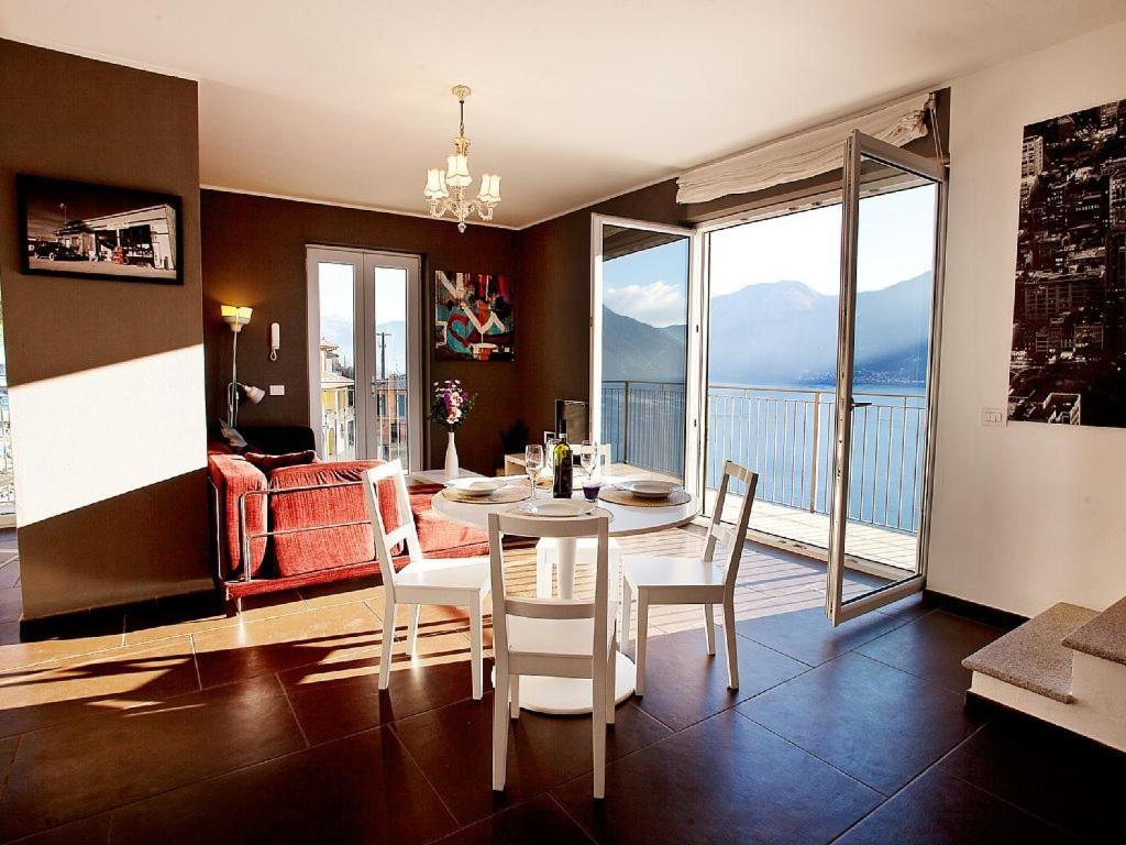 a dining room with a table and chairs with a view at Colonno Apartment in Sala Comacina