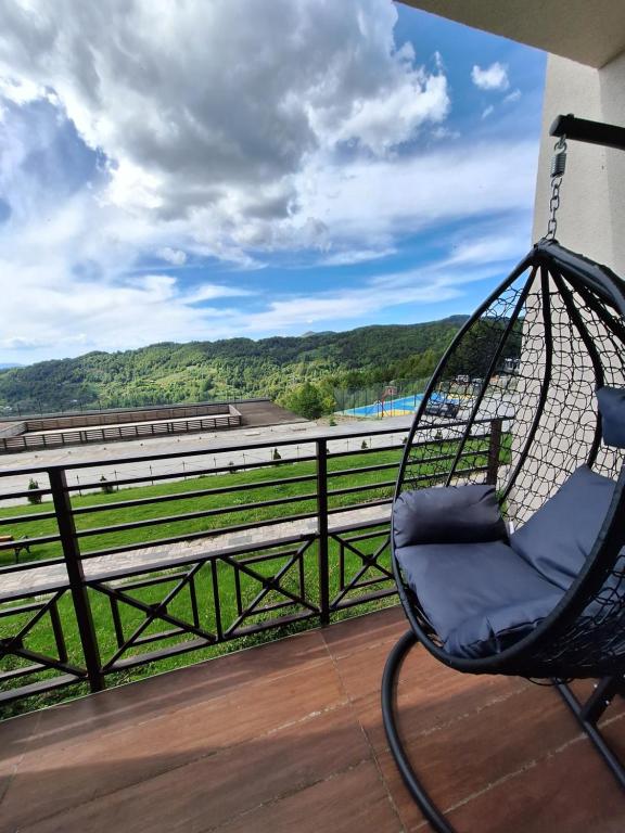 a swing chair sitting on a balcony with a view at Apartmani L6 & P90 Milmari Kopaonik in Kopaonik