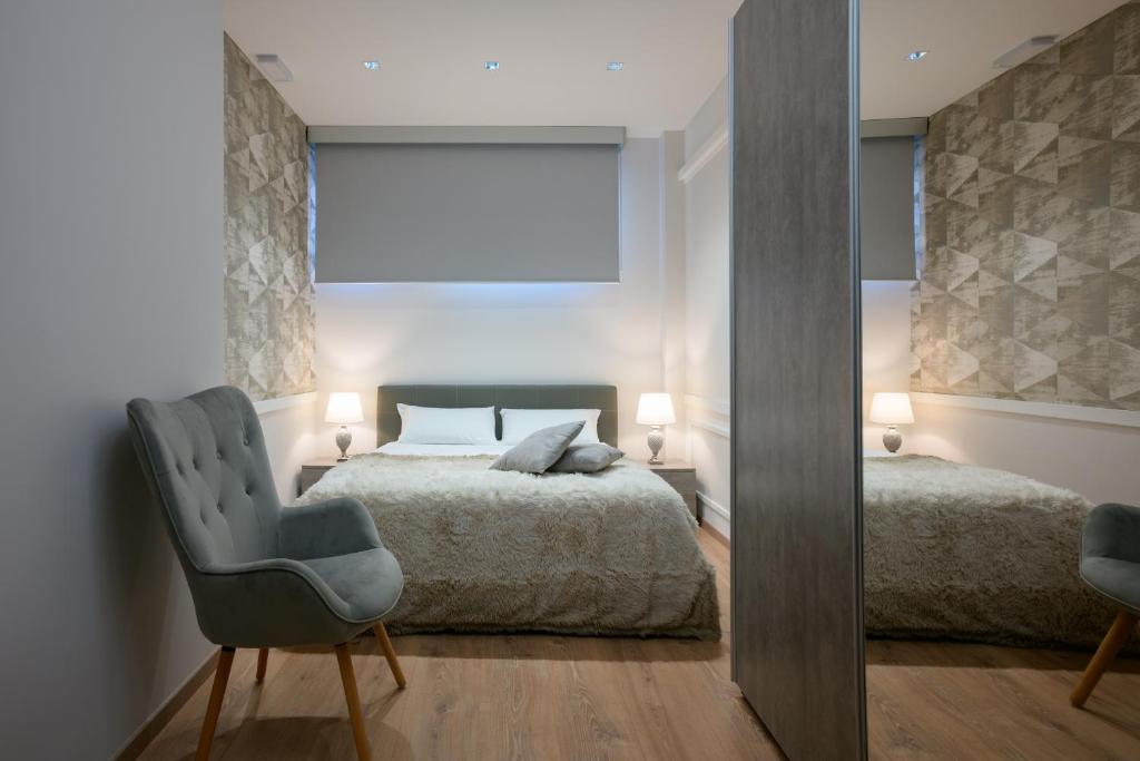 フィウミチーノにあるLoft Sea&Sky Fiumicino Airportのベッドルーム1室(ベッド1台、椅子、鏡付)