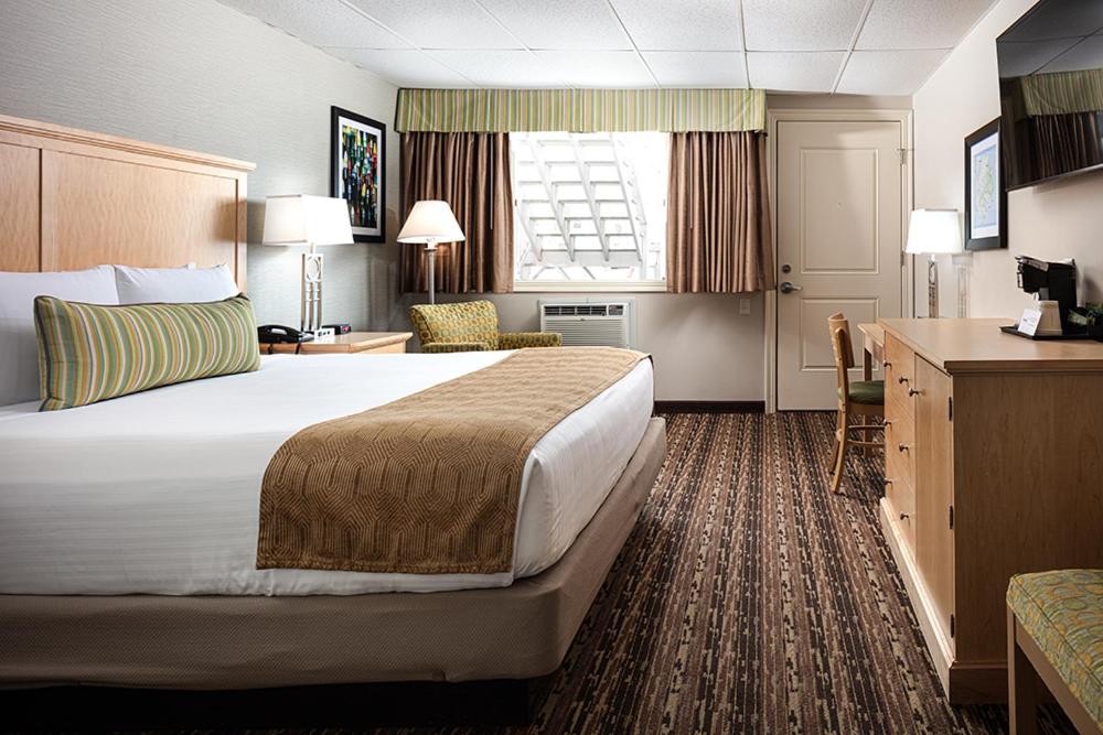 um quarto de hotel com uma cama grande e uma secretária em Bar Harbor Villager Motel - Downtown em Bar Harbor