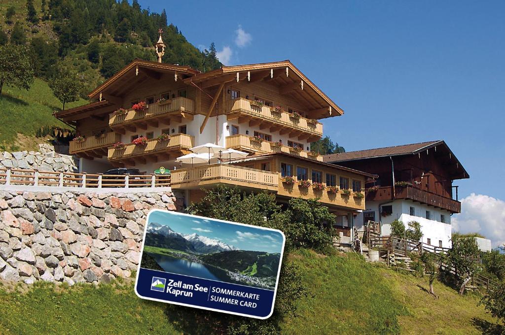 a building on a hill with a sign in front of it at Jausenstation Pfefferbauer in Zell am See