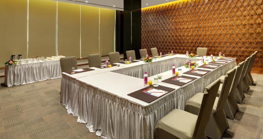 a row of tables in a room with chairs at Click Hotel Bhuj in Bhuj
