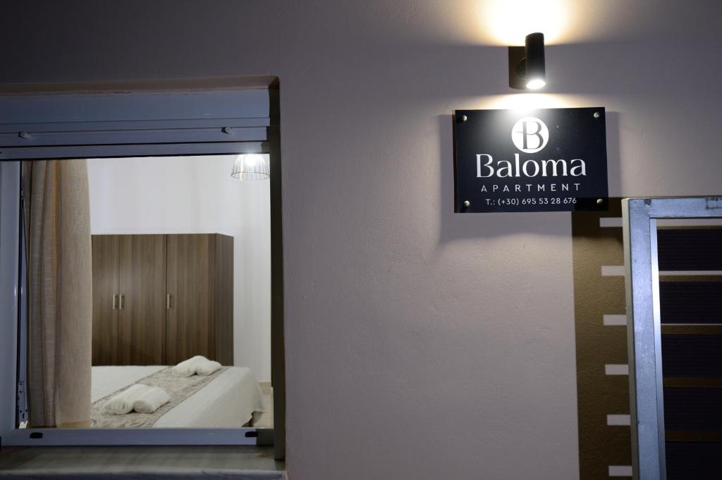 a bathroom with a mirror and a sign on the wall at Baloma Apartment in Falasarna