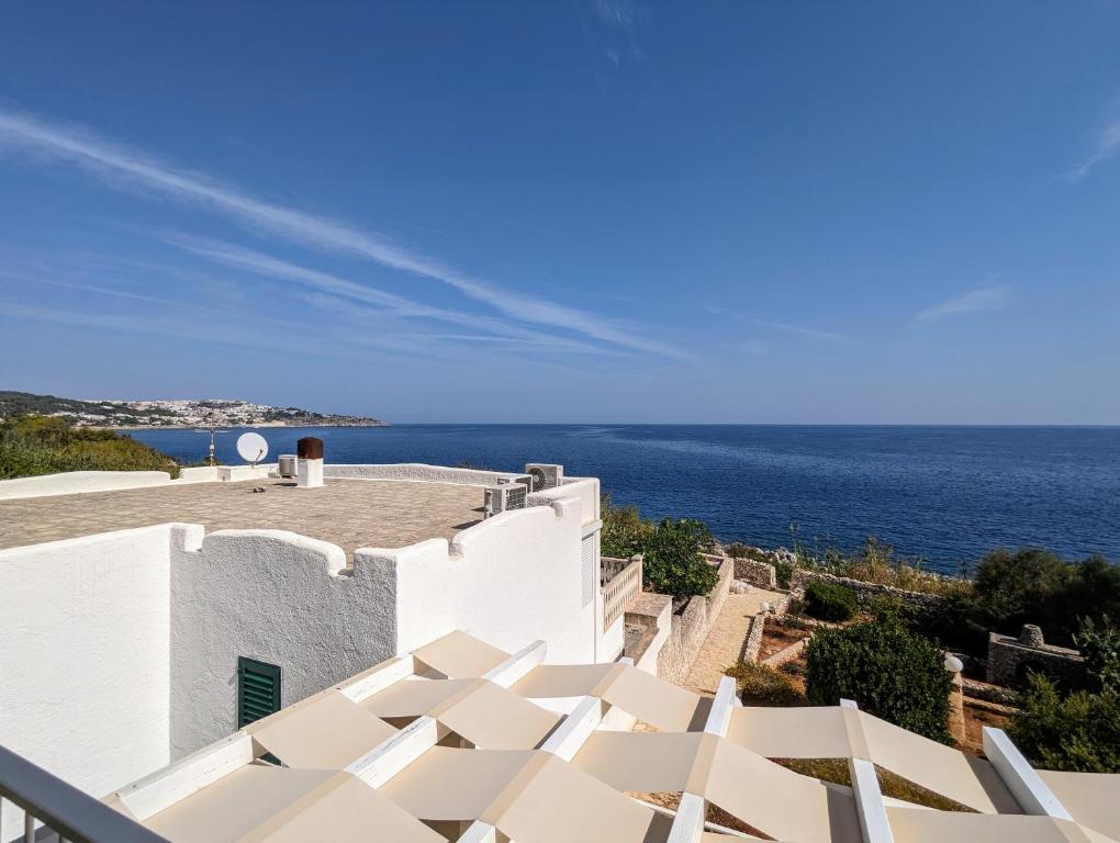 a white building with the ocean in the background at Casa Cuti Cuti in Marittima