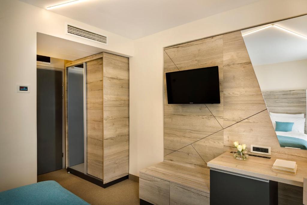 una habitación de hotel con TV en la pared en Hotel Marina - Liburnia, en Mošćenička Draga