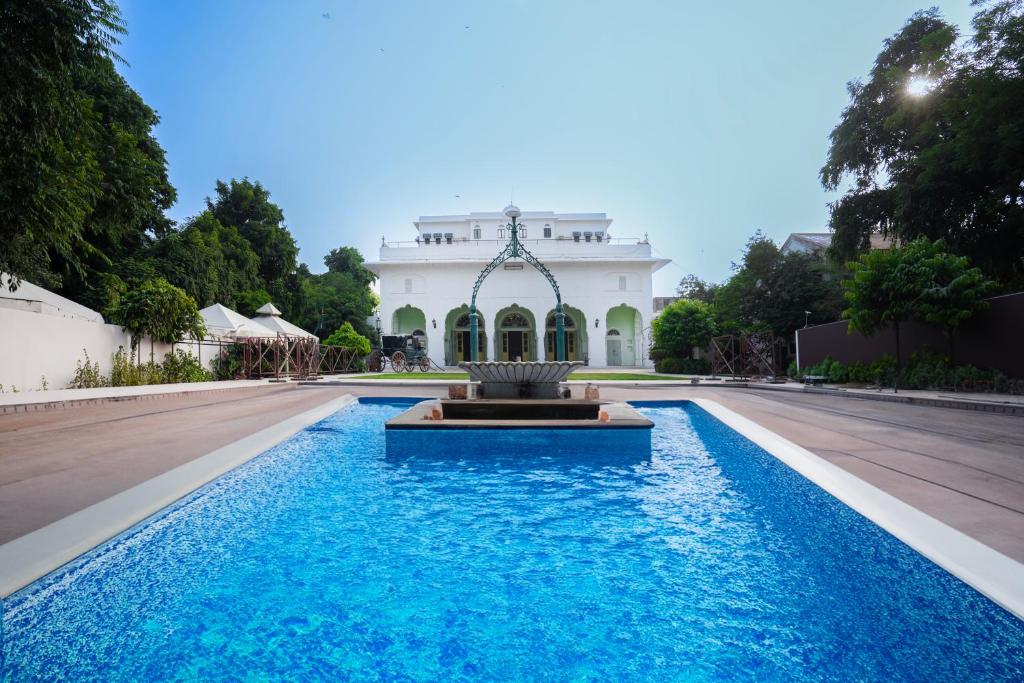 een zwembad met een fontein voor een gebouw bij Diggi Palace - A City Center Hidden Heritage Gem in Jaipur