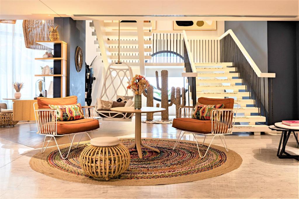 une chambre avec des chaises, une table et des escaliers dans l'établissement Hotel Croisette Beach Cannes - Mgallery, à Cannes