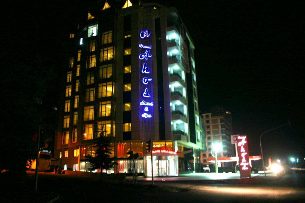 a tall building with a blue sign on it at night at Grand Ahos Hotel & Spa in Ereğli