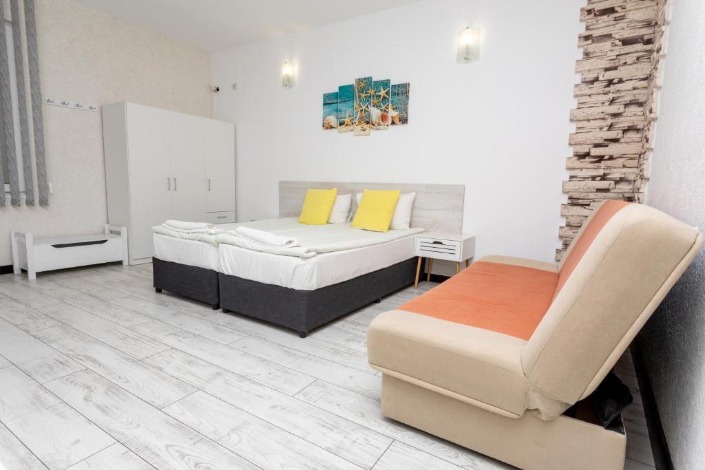 a bedroom with two beds and a chair at Guest rooms and apartments Desi in Balchik