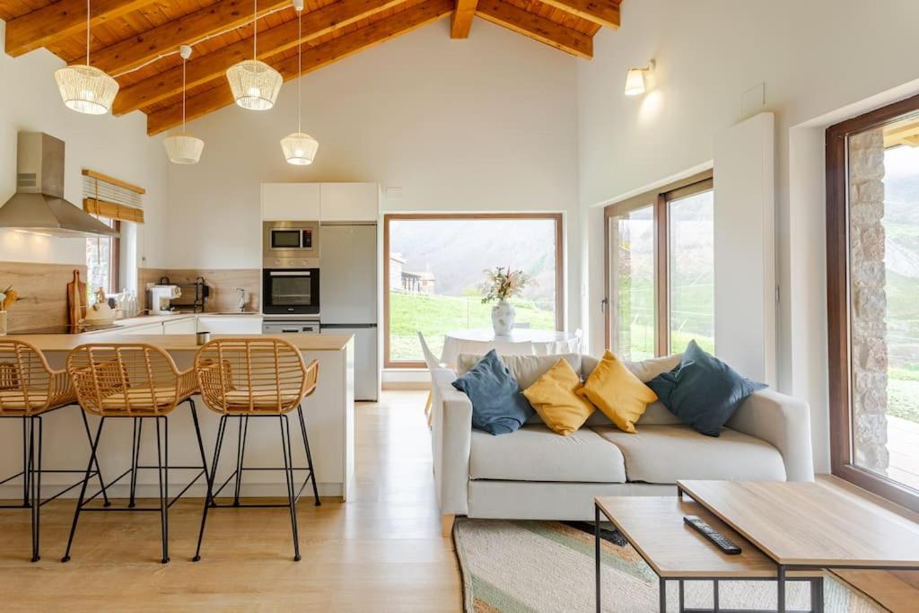 a living room with a couch and a kitchen at Relax en Somiedo in La Peral