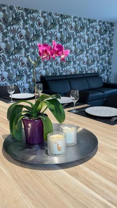 une table avec un vase et une fleur sur elle dans l'établissement La Cerisaie, à Talant