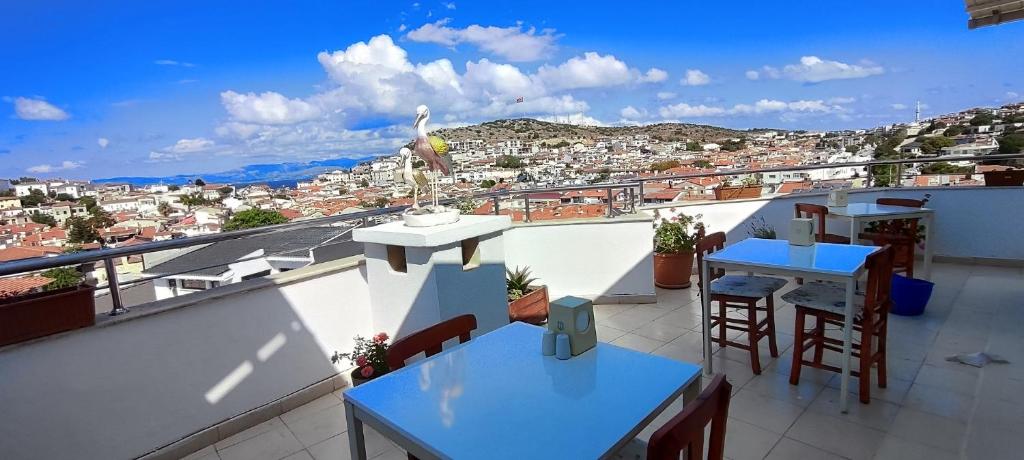 balcón con mesas y vistas a la ciudad en Bonapart Hotel, en Cesme