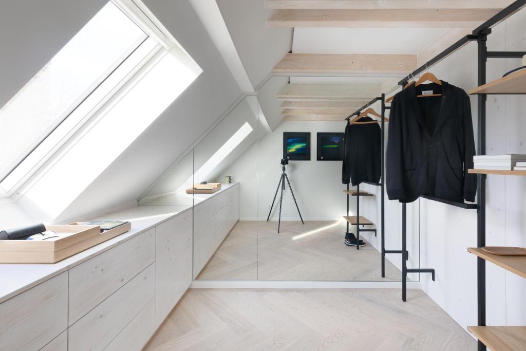 Zimmer mit weißen Wänden und Oberlichtern in der Unterkunft HOMEFY - Luxury Art Apartment in Düsseldorf