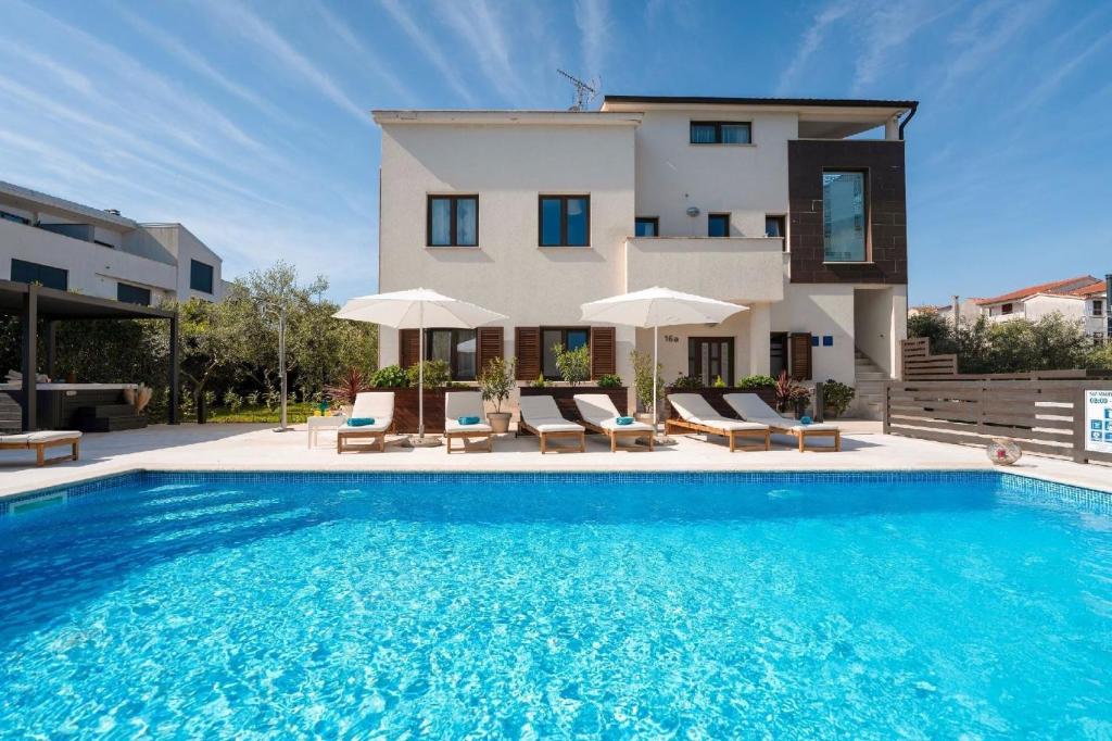 uma villa com piscina em frente a uma casa em Ferienwohnung Residence Mala 1 mit Pool em Funtana