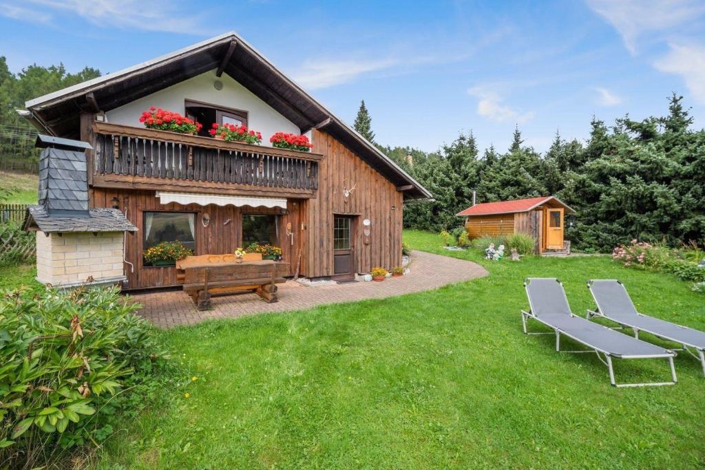 a log cabin with a table and benches in a yard at Ferienhaus Panoramablick in Piesau