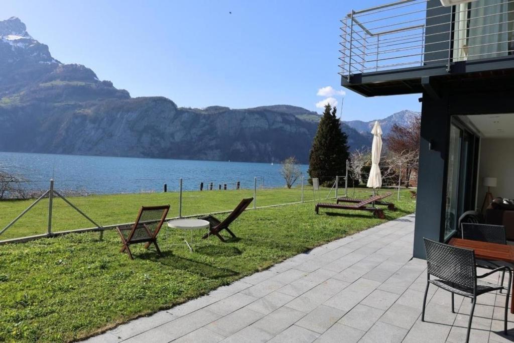 een patio met uitzicht op een meer en de bergen bij Ferienvilla am See 3 für 2-4 Personen in Sisikon