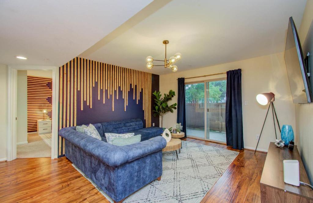 a living room with a blue couch and a table at 3 Bedrooms Spacious Central Condo w Pool in Houston