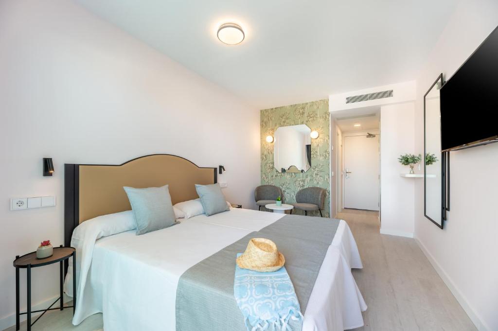 1 dormitorio con 1 cama con sombrero en Hotel Vibra Palma Cactus, en Playa de Palma