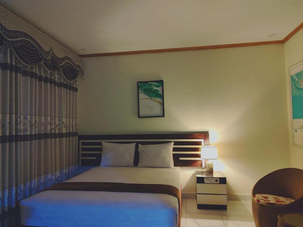 ein Hotelzimmer mit einem Bett und einem Stuhl in der Unterkunft H.V HOTEL BANDARA in Gorontalo