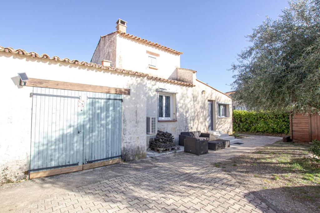 une maison blanche avec un portail et une clôture dans l'établissement La Maison du Lac - Puimoisson, à Puimoisson