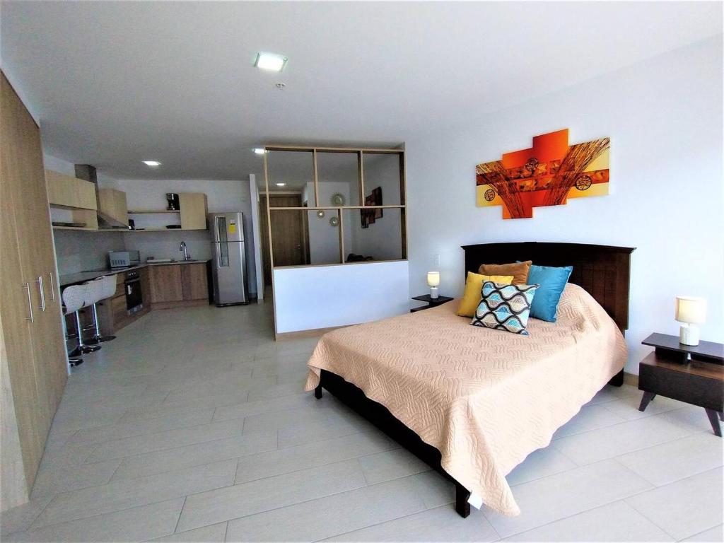 um quarto com uma cama grande e uma cozinha em Suite Piso #20 Con Vista Al Pichincha em Quito