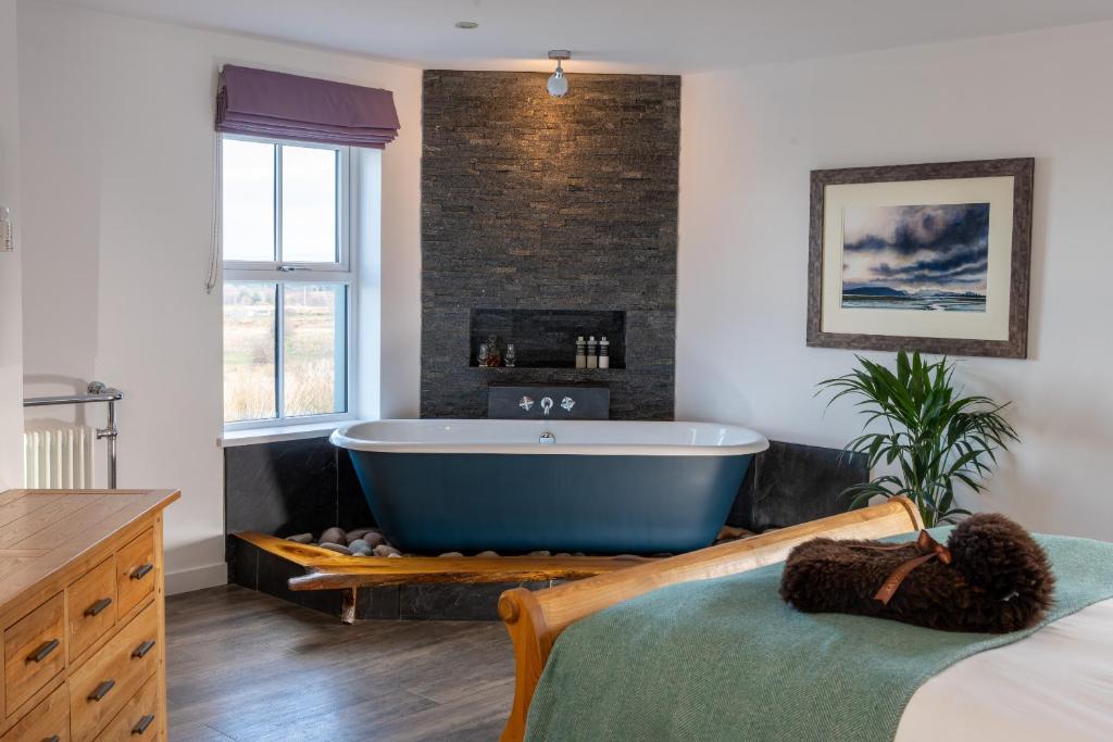 a bathroom with a large bath tub in a room at Dark Skye Cottage in Broadford