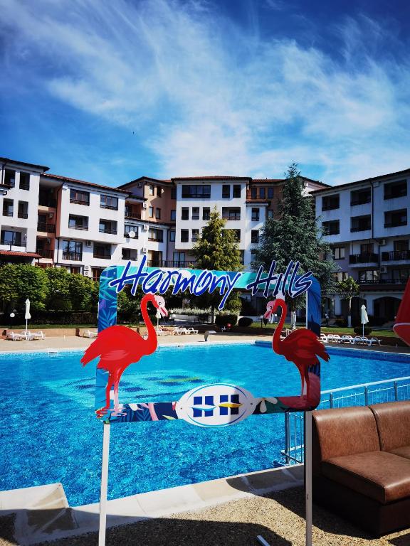 two flamingos standing in front of a swimming pool at Harmony hills view apartments in Rogachevo
