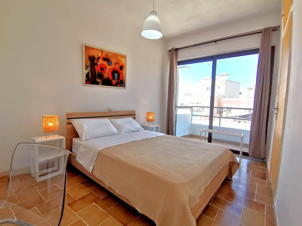 1 dormitorio con cama y ventana grande en 3rd floor apartment in town with sea view, en Rodas