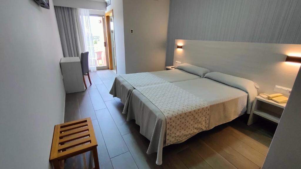 um quarto de hotel com uma cama e uma televisão em Hotel La Lanzada em A Lanzada