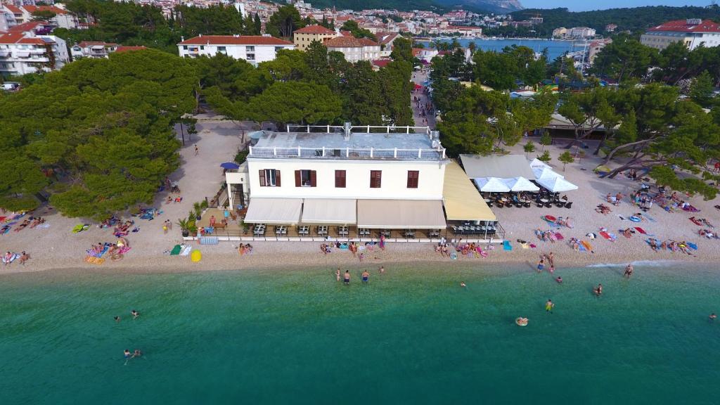 una vista aerea su una spiaggia con un edificio bianco di Beach rooms Riviera - Žuta Kuća a Makarska