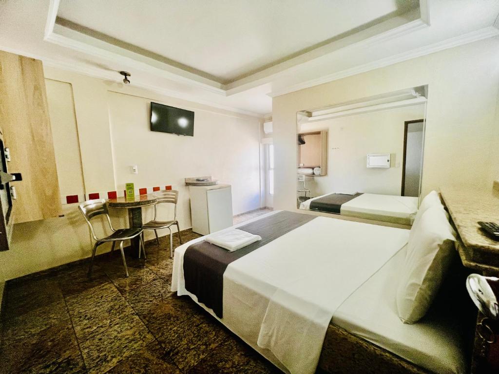 Hotel Buriti Shop في غويانيا: غرفة فندقية بسريرين وطاولة