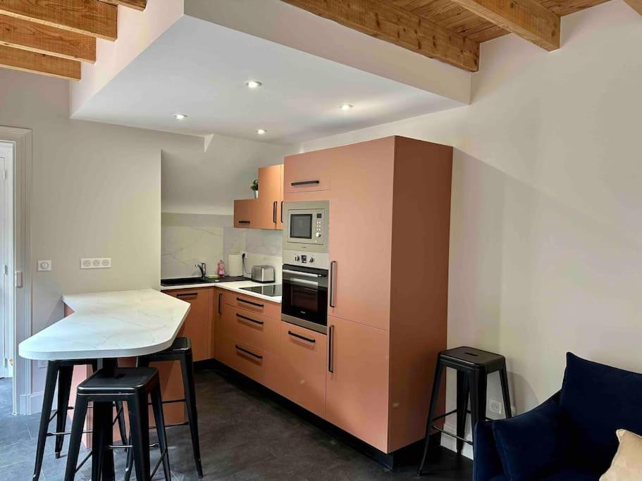 - une cuisine avec un comptoir et quelques tabourets dans l'établissement Maison Fitzgerald, à Vichy