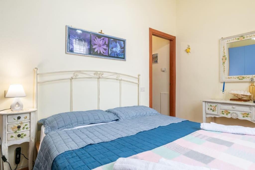 Un dormitorio con una cama azul y dos mesitas de noche. en Coastal Heaven, Spacious apartment near the beach, en Marina di Pisa