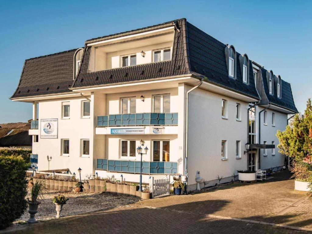 a large white building with a black roof at Aquarius Ferienwohnung Usedom in Loddin