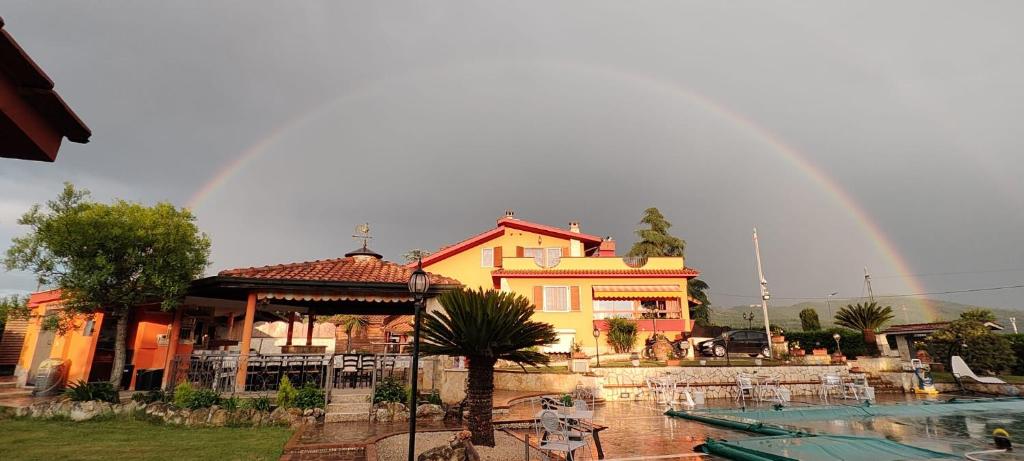 um arco-íris sobre uma casa com piscina e uma casa em B&B Ferro di Cavallo em Tivoli