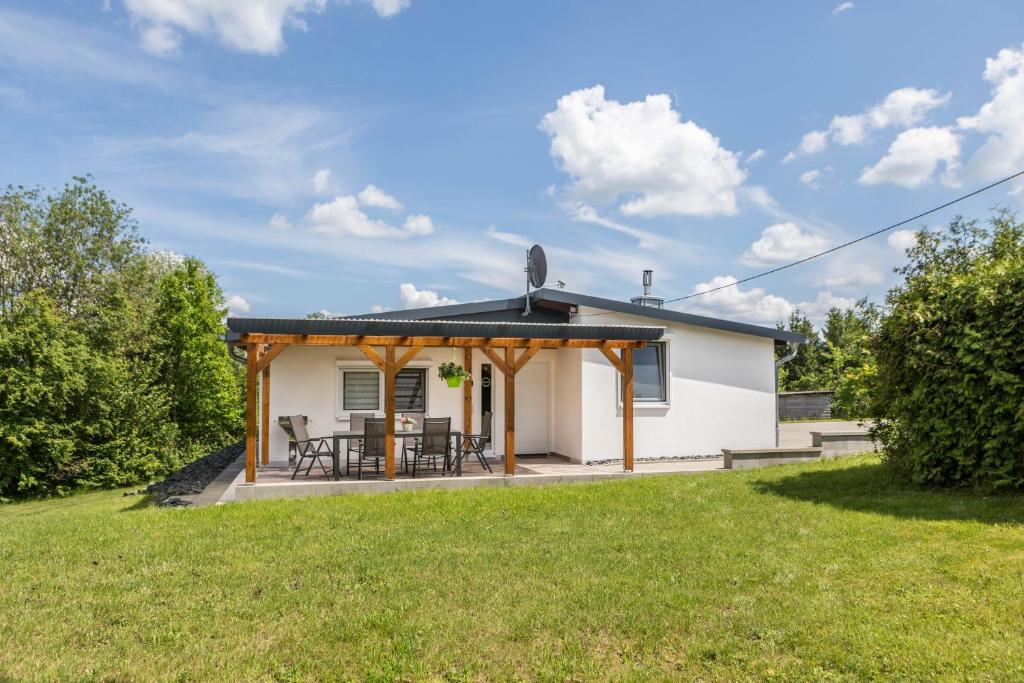 a cottage with a patio and grass yard at Ferienhaus Bornwiese in Schwalmtal
