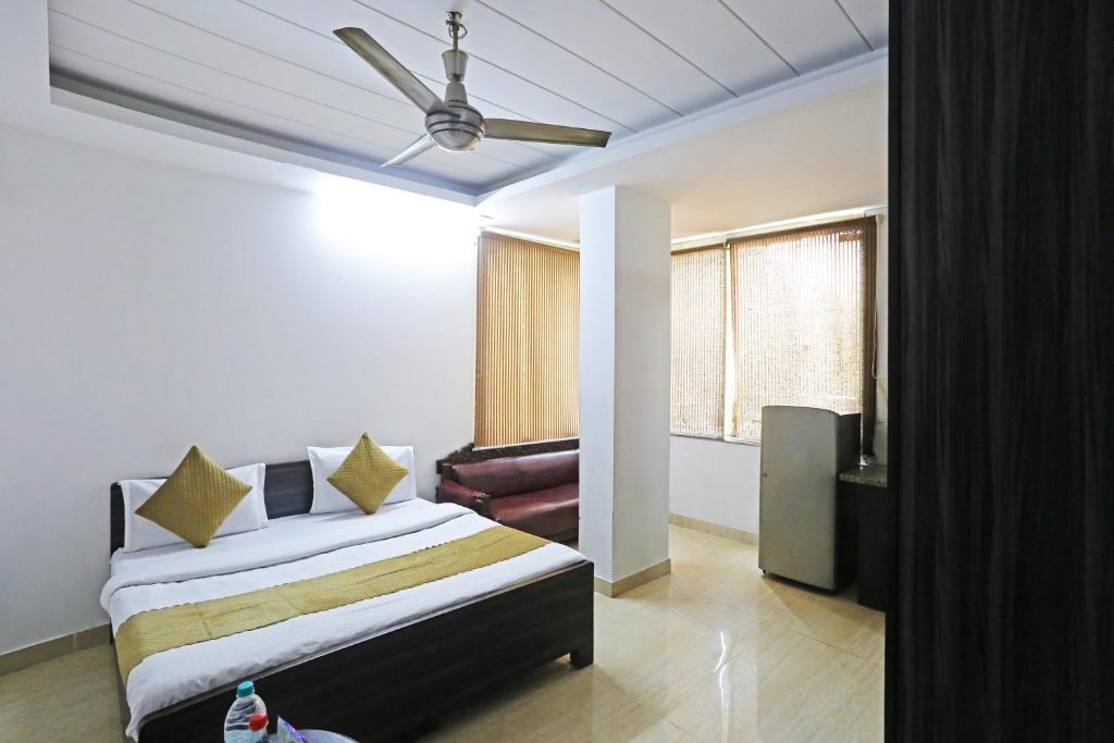 a bedroom with a bed and a ceiling fan at Hotel Premium Room Near Hazrat Nizamuddin railway station in New Delhi