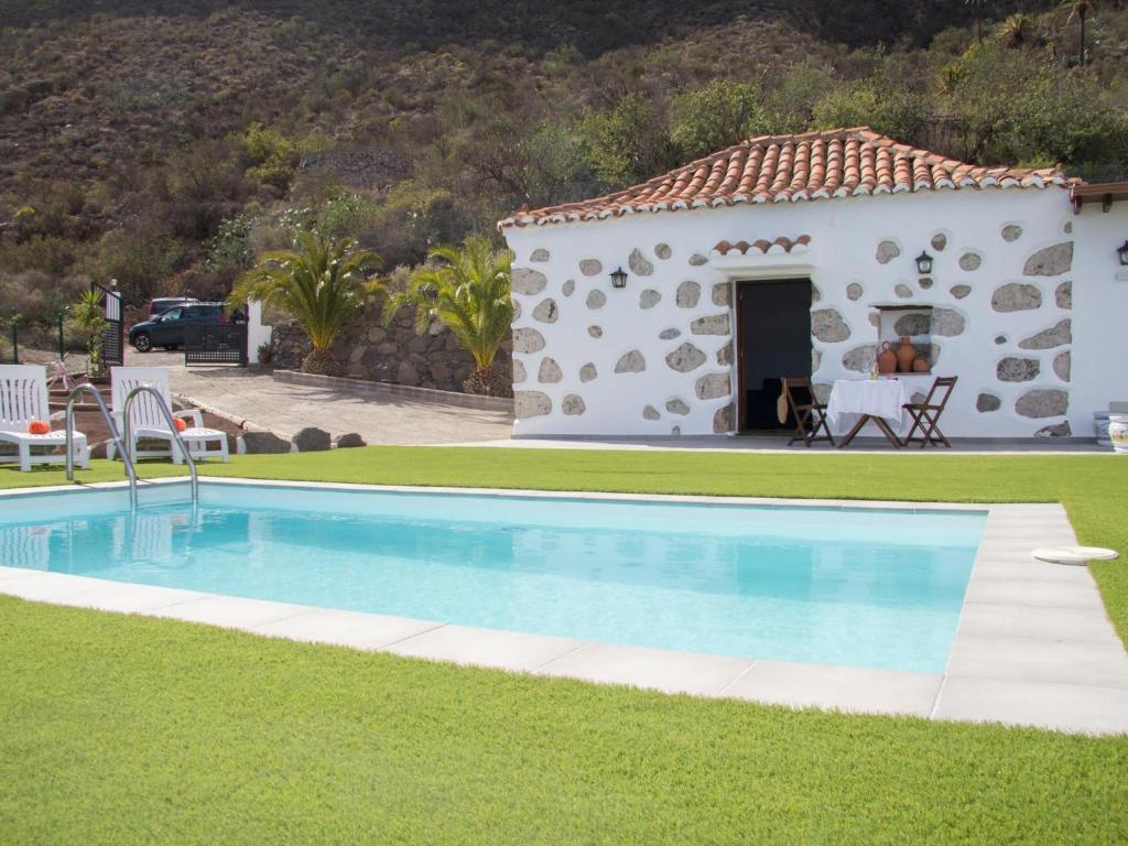 eine Villa mit einem Swimmingpool vor einem Haus in der Unterkunft Vivelorural Abuela María 1, chill garden pool in San Bartolomé de Tirajana